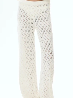 Vita virkade vida leggings - Säljer ett par vita virkade leggings med vida ben och snyggt hålmönster. De har hög midja och ett luftigt, bohemiskt uttryck som passar perfekt till sommaren. Materialet är mjukt och stretchigt, vilket gör dem riktigt bekväma att bära.