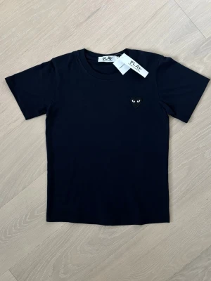 CDG T-Shirt - CDG t-shirt säljes. Ny och oanvänd. Passar storlek XS/S.  Hör gärna av dig om du vill ha fler bilder eller har frågor. Jag skickar inom 24 timmar📦