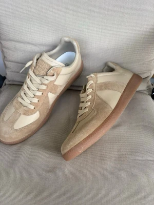 Maison Margiela Gats - Hej! Jag säljer ett par Maison Margiela GATs i fint skick, storlek 43. Beigefärgade, skitsnygga.  De köptes från NK, inköpsbevis visas vid intresse. Köptes ett tag sedan och har knappt använts.  Endast skor och dustbag medföljer, box är tyvärr borta. Säljer av lite plagg från garderoben nu. Skriv om ni har några som helst frågor. 