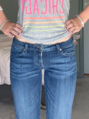 Lågmidjade bootcut jeans - Mörkblåa lågmidjade bootcut jeans som är omsydda. Passar runt xs
