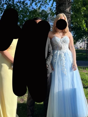 Ljusblå balklänning med spetsdetaljer - Köpt från zapaka för 1500kr. Uppsydd för att passa mig som är 160cm(med klackar) mamma och sytt och klippt efter min längd+klackar. Använd 1 gång på studentbalen. Normal i storlek kan skickas mera bilder privat. 