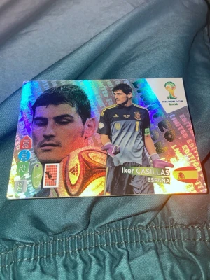FIFA World Cup Brasil spelkort - Snyggt holografiskt samlarkort från FIFA World Cup Brasil med motiv av Iker Casillas från Spanien. Kortet har färgstark design med fotbollstema och officiell turneringslogga. Perfekt för dig som gillar fotbollsspel och samlarkort.