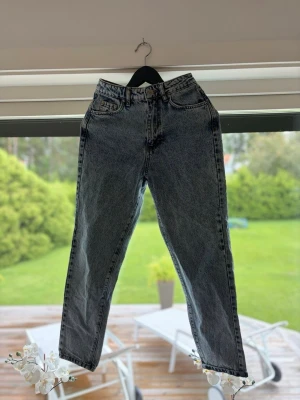 Blå  mom jeans med hög midja - Snygga gråsvarta mom jeans med hög midja och raka ben. Klassisk femficksmodell med dragkedja och knapp framtill. Jeansen har en tvättad look och är tillverkade i denim, perfekt för en avslappnad och trendig stil.