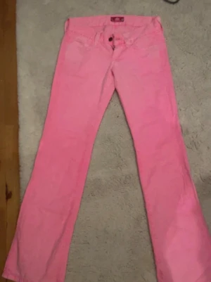 Lågmidjade rosa jeans  - Rosa lågmidjade jeans från fornarnia. Storlek 27. Innerbenslängden är ca 86cm. Tunnare än vanligt jeanstyg. Lite skrynklig men går nog bort om man stryker. Kommer inte gå ner mer i priset eftersom de köptes för över 1000kr. Knappt använda 
