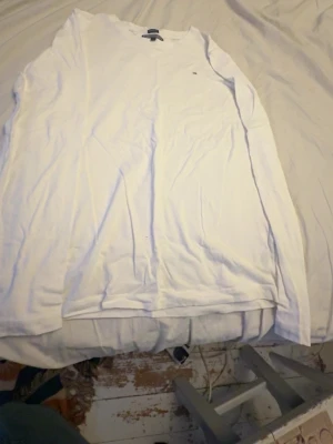 2 Vita långärmad toppar från Tommy Hilfiger - Klassisk vit långärmad topp från Tommy Hilfiger med rund halsringning och liten logga på bröstet. Tillverkad i mjuk bomull som känns skön mot huden. Perfekt basplagg att ha i garderoben. 2st. 1 för 100 2 för 150