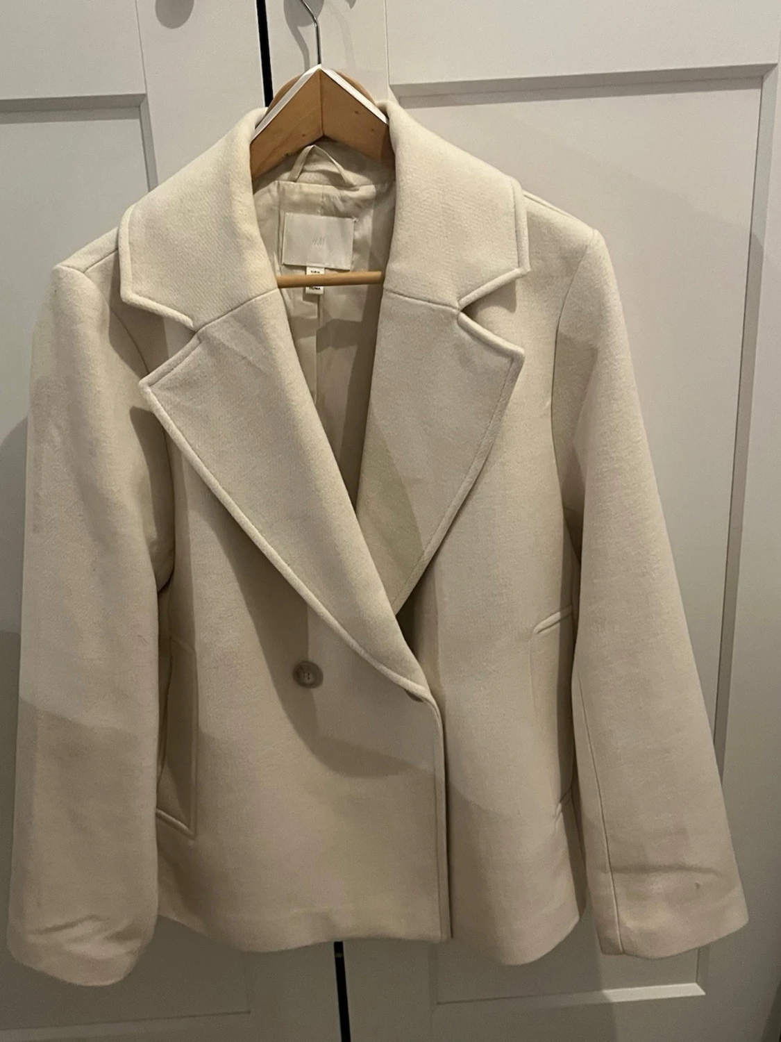 Créme färgad kappa från H&M