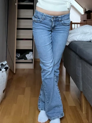 Ljusblå lowwaist bootcut jeans - Säljer ett par ljusblå bootcut jeans låg midja. Stl 164 eller 35 cm tvärs över och 77 cm i innerbenslängd