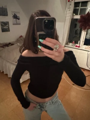 Svart offshoulder topp - Svart offshoulder topp med långa ärmar och croppad passform. Mjuk och stretchig känsla, sitter snyggt över axlarna.