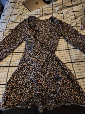 Omlott klänning ONLY - En klänning som använts kanske 1-2ggr men den är inte riktigt min stil så jag säljer den. Det är lite svårt att visa på bilderna hur den ska knytas men de är enkelt i verkligheten. Den är luftig och väldigt fin. Ganska kort i kjolen och långärmad.