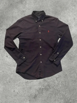 Ralph Lauren Skjorta - Säljer ni denna väldigt fina Ralph Lauren skjorta med den klassiska röda hästen på bröstet. Enkel att matcha med ett par schysta jeans, kostymbyxor eller linnebyxor. Storlek M i modellen Slim fit. Den är använd med fortfarande i fint skick med mycket kvar att ge. Pris kan diskuteras 🙌