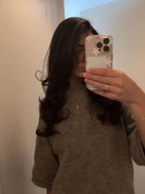 Beige stickad tröja med rund hals - Mysig beige stickad tröja med rund hals och uppvikta ärmar. Tröjan har en avslappnad passform och är perfekt för lager-på-lager. Passar till både jeans och kjol för en enkel, stilren look.