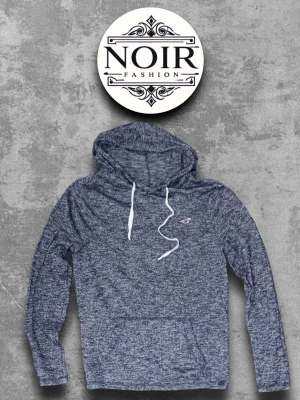 Melerad blå hoodie från Hollister - Säljer en snygg melerad blå hoodie från Hollister med vit dragsko och huva. Hoodien har en klassisk passform, lång ärm och en liten logotyp på bröstet. Perfekt för dig som gillar en avslappnad och trendig stil.