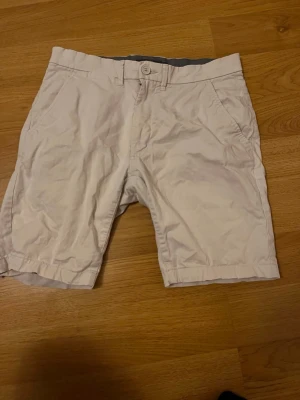 Vita shorts från Dressmann - Snygga vita shorts från Dressmann i klassisk modell med knapp och dragkedja framtill. Tillverkade i bomull för en skön känsla och har sidofickor. Perfekta för varma dagar och enkel att matcha med olika stilar.