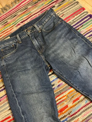 Blå raka jeans Levis premium jeans  - Säljer ett par sjukt feta klassiska blå Levis premium  jeans med rak passform och snyggt slitna detaljer. Jeansen har fem fickor, normal midja och är gjorda i kraftigt denimtyg. Perfekta för en avslappnad och tidlös stil. Jeansen är i storlek W30 och L32 säljer så billigt eftersom jag behöver sälja snabbt! 