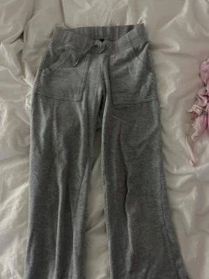 Grå mjukisbyxor Juicy Couture - Säljer ett par grå mjukisbyxor från Juicy Couture. Byxorna har stora fickor framtill och ett diskret Juicy Couture-broderi på ena fickan. Har en liten fläck på framsidan men inget man tänker på. Nypris 999:-