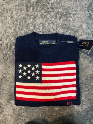 Polo Ralph Lauren USA flaga - mörkblå/navy - Tjena! Säljer nu denna nya Ralph lauren usa flaga tröjan. Den är mörkblå, och är ny. Endast testad. Storlek S, kan passa som en M beroende på. Medföljer taggarna och og påse. Vid frågor kontakta gärna!  Tjej modell, men har även en kill modell i profilen 