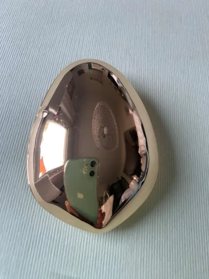 Spegelblank hårklämma i metall - Säljer en snygg hårklämma i spegelblank guldfärgad metall med mjukt, organiskt formad design. Klämman har en robust metallklämma på baksidan som håller håret på plats. Perfekt för att ge din look en futuristisk touch.