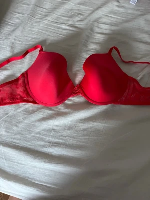 Röd bh, primark  - En röd bh från primark. Knappt använd. Den ser lite konstig ut på bilden då kuporna faller ihop om man inte har på sig den. Den är i storlek 80C