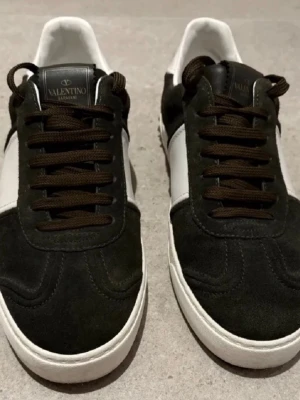 Valentino Garavani Flycrew strl 41 - Säljer ett par sjukt sällsynta Valentino Flycrews i mörkgrön/olivfärgade. De är i storlek 41 och allt på bilderna medkommer. De är i bra skick och alla nitar är kvar. Perfekt för dig som vill sticka ut lagom från mängden. Hör av er vid frågor och funderingar!