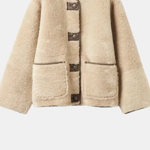 Beige teddyjacka med stora fickor - Mysig beige teddyjacka med rund halsringning och stora framfickor. Jackan har dekorativa bruna knappar och detaljer längs kanterna. Tillverkad i fluffigt teddy-material som ger en trendig och avslappnad look. Köpt för 1499kr och säljer för 1199kr men är öppen för förhandling vid snabb affär