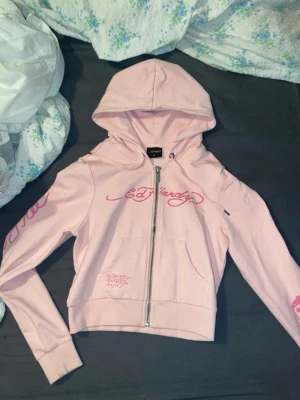 Ed Hardy hoodie  - Ed Hardy hoodie med dragkedja, rosa med rosa detaljer. Storlek M men passar S. Köpt på Nelly.com. Äkta. Inga defekter 