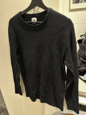 Svart ribbstickad tröja från Zara - Svart ribbstickad tröja från Zara i storlek XL. Tröjan har rund halsringning och långa ärmar, perfekt för en stilren och enkel look. Passar L och i vissa fall M också. Tillverkad i Portugal och passar dig som gillar minimalistisk stil. Skriv över det minsta lilla eller över den minsta funderingen!🔥🔥