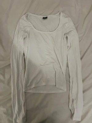 Vit långärmad topp med vid ringning - En populär basic vit långärmad topp från Gina Tricot med bred, rund ringning. Modellen är croppad och har en enkel, stilren design som passar till många olika outfits. !!Om du köper välj gärna att hämta vid upphämtningsställe istället för hemleverans då det blir enklare för mig att posta på det viset!!