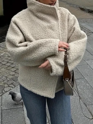 Beige oversized teddyjacka - Mysig och trendig beige teddyjacka med hög krage och oversized passform. Jackan har en fluffig textur och stängs framtill. Perfekt för kalla dagar och ger en cool streetstyle-look. Köpt på SHEIN för ca 350-400kr, använd 1 gång