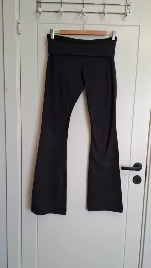 Svarta utsvängda leggings - Svarta yoga pants från Brandy Melville. Mjukt och stretchigt material som sitter skönt på kroppen. Perfekta för en avslappnad och trendig look. Lite slitna på bottnet. 