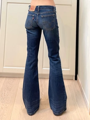 Lågmidjade vintage bootcut jeans från Levis - Mått: 35x2 cm, gren 19 cm och innerben 80 cm. Storlek W26/L32 vilket motsvarar XS enligt google. Jag är xs och 170 för referens. Uppskattad storlek: XXS/XS. Men det är storleksmärkningen och måtten (mätta på mitt sätt) som gäller om man köper. Inga defekter❤️