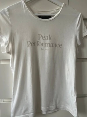 T-shirt - Vit t-shirt med tryck från peak performance i storlek xs.