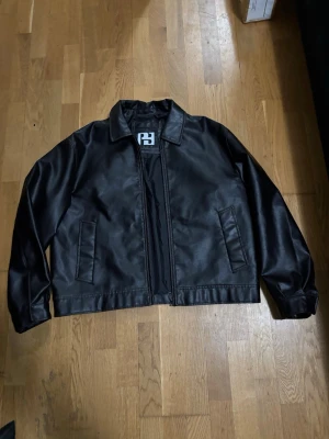 Svart läder jacka - Pull and bear  - Helt ny, använd bara för att prova. Stilren svart jacka i mjukt konstläder med klassisk design. Storlek L, normal passform. Perfekt för vardag eller som en snygg statement-jacka. Skicket är utmärkt – redo att användas direkt! Storlek - L 