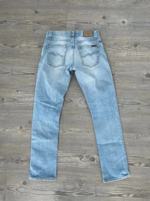 Nudie Jeans - Säljer ett par ljusblå jeans från Nudie Jeans, riktigt snygga och fräscha. Storlek w30 L32, grim Tim model, slim fit. Mått längd 103cm, midja 40cm. 