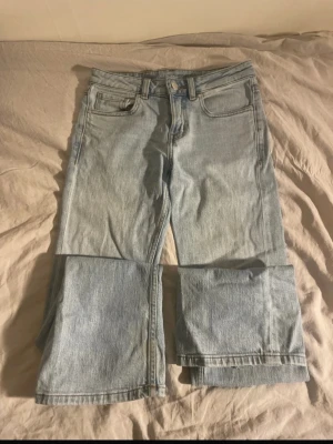 Ljusblå vida jeans med avtagbara ben - Unika ljusblå jeans med bred passform och avtagbara ben som gör dem till både långa jeans och shorts. Klassisk femficksmodell med knapp och dragkedja. Perfekta för dig som vill ha en cool och flexibel stil. Tillverkade i denim.