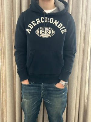 Blå Abercrombie & Fitch hoodie - M - Mycket fint skick och inga defekter. Modellen på bilden är ca 180 cm. Skriv om du undrar över något💸