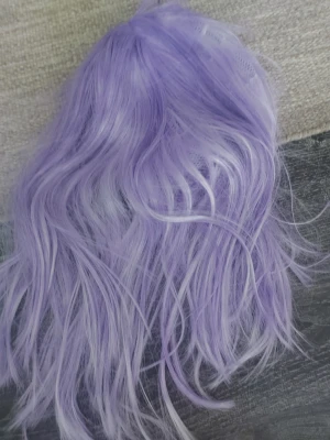 Lång spraypaintad lila cosplayperuk - Säljer en lång och vågig peruk i ljuslila syntetfiber, perfekt för cosplay eller maskerad. Jag använde den för att cosplay spektra från Monster High. Peruken har naturligt fall och är lätt att styla. Ingen synlig märkning. Passar dig som vill ha en färgstark look till din outfit. 