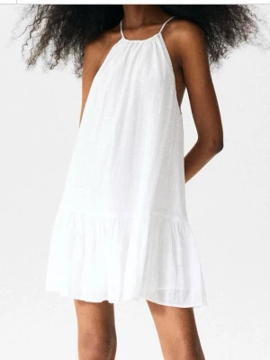 Vit klänning med öppen rygg  - Säljer denna superfinavita luftiga klänningen med öppen rygg. Klänningen är gjord i ett linne liknande material och är perfekt för varma dagar eller till stranden!