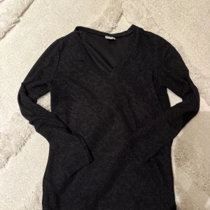 Svart v-ringad topp Saint Tropez - Mjuk och enkel svart långärmad topp från Saint Tropez med v-ringning. Perfekt basplagg med normal passform och stilren look. Passar till allt och är lätt att matcha med andra plagg.