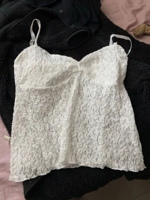 Vit spetslinnetopp med smala band - Säljer en söt vit linnetopp med tunna axelband från Nelly som är slutsåld!😊