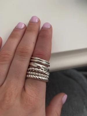Snygga silverfärgade ringar i olika mönster - Säljer ett set med sex stilrena ringar i silverfärgad metall. Ringarna har olika designer, bland annat släta, tvinnade och pärlinspirerade mönster. Perfekta att mixa och matcha för en personlig look. Från hm, aldrig använda i storlek 17/18