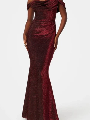 Vinröd glittrig långklänning - INTRESSEKOLL!! Snygg vinröd långklänning med glittrigt tyg och offshoulder-design. Klänningen har en draperad urringning och figurnära passform som framhäver siluetten. Under bysten sitter även det även metal som gäller till att hålla upp och forma brösten. Använd 1 gång. 