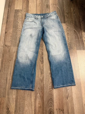 Wide leg jeans med blekt effekt - Säljer ett par ljusblå wide leg jeans med blekt effekt på benen. 