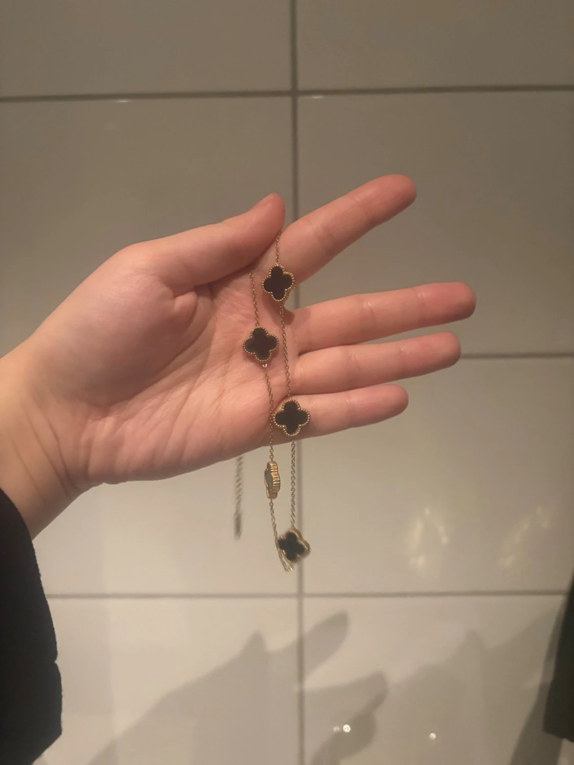 Guldarmband med svarta klöverhängen