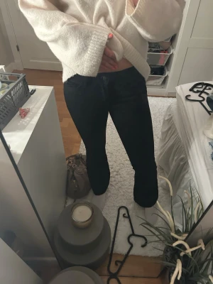 Svarta flare jeans - Säljer ett par svarta jeans med klassisk femficksdesign. Jeansen har normal midja och stängs med knapp och dragkedja. Perfekta till en avslappnad och stilren look.