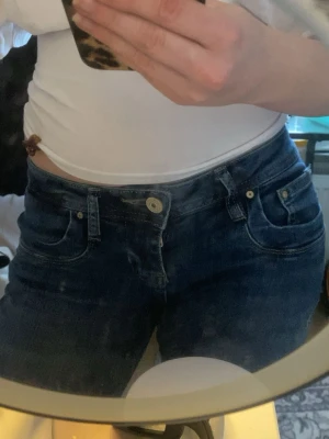 Mörkblå jeans från LTB - Snygga mörkblå jeans från LTB i storlek w24 längd 30 som passar mig som är runt 1,60. En klassisk femficksmodell och normal midja. Jeansen har raka ben och guldfärgade nitar vid fickorna. Perfekta för dig som gillar en enkel men stilren look. Kolla sista bilder för defekter. 