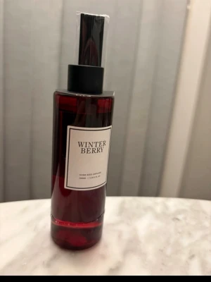 Winter Berry doftpinnar oanvänd  - Säljer en flaska Winter Berry doftpinnar med mörkröd vätska och svart lock. Flaskan är cylinderformad och etiketten är vit med svart text. Perfekt för att sprida en fräsch bärig doft i hemmet. Oanvänd 