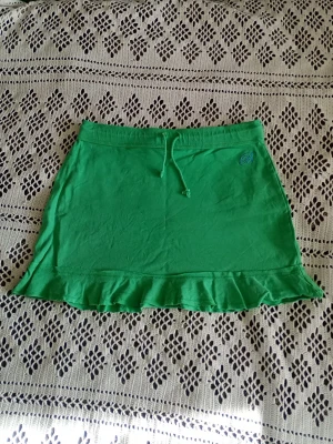Grön y2k kjol - Grön kjol i mjukismaterial från vintage Bikbok. Supersöt blå broderad logga. Snörning i midjan och volang nedtill. Står M men mer som S🩷