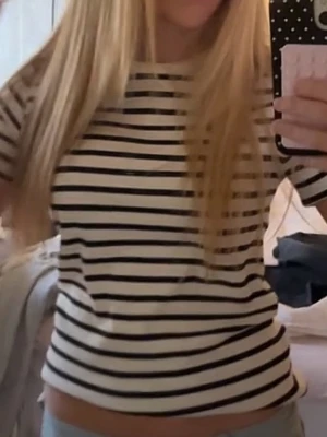 Randig vit och svart t-shirt - Säljer en klassisk vit t-shirt med svarta horisontella ränder. T-shirten har korta ärmar, rund halsringning och är gjord i mjukt bomullsmaterial. Perfekt till jeans eller kjol för en enkel och stilren look.