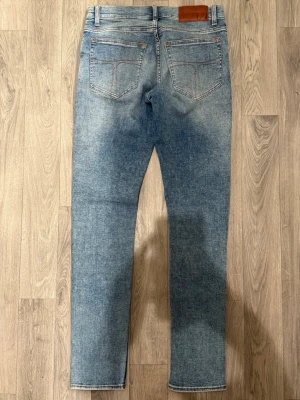 Tiger of Sweden Evolve Jeans Blå W30 L34 - Sjukt snygga blåa Tiger of Sweden Evolve jeans i mycket fint skick (Knappt använda) i storlek W30/L34. Mått - Midja: 38cm, Benlängd: 104cm. Modellen är 185cm & 63kg. Hör av dig vid funderingar!🤝