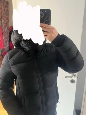 Svart pufferjacka med huva - Säljer en svart pufferjacka med stor, mysig huva och dragkedja framtill. Passar dig som vill ha en stilren och varm vinterjacka. Den är ifrån Everest i storlek S, nypris: 2499:-